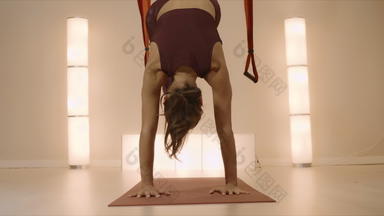 女人练习瑜伽航空瑜伽工作室瑜伽教练站手席